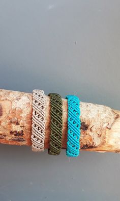 three different bracelets are sitting on a branch