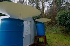 a blue and white cooler sitting on top of a grass covered field next to trees