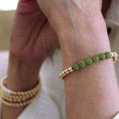 Elevate your style with the enchanting 14k Gold Filled 6mm Bead Bracelet with Jade, from our exquisite LEAHJESSICA Collection. Superior Quality: Features 14k gold-filled 6mm beads harmoniously paired with vibrant jade accents, ensuring both beauty and longevity. Versatile Design: Ideal for solo wear or as an elegant addition to any arm stack, this bracelet adds sophistication to any look. Comfort and Fit: Crafted with an elastic stretch for a snug and comfortable fit, while the lightweight desig Elegant Gold Beaded Bracelets With May Birthstone, Hand-strung Gold Bracelets For May Birthstone, Gold Stackable Beaded Bracelets For Healing, Gold Hand-strung Bracelets For May Birthstone, Elegant Hand-strung May Birthstone Beaded Bracelets, Gold Hand-strung Jewelry For May Birthstone, Gold Bracelets With Polished Beads For Healing, Arm Stack, Gold Bead Bracelets