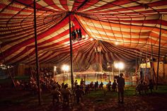 a circus tent with people inside at night