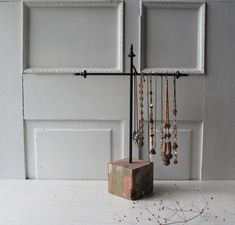 a jewelry rack with several necklaces hanging from it's sides next to a door