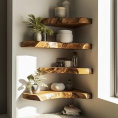 three wooden shelves with plants and vases on them in the corner of a room