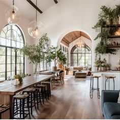 a living room filled with furniture and lots of windows next to a dining room table