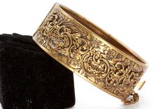 "DESCRIPTION: This antique bangle bracelet is designed to create this Victorian Revival piece, featuring a brass-tone finish with intricate details that are reminiscent of the Victorian era. The ornate design is a perfect accessory for those who appreciate vintage and antique jewelry. The bangle is sturdy and durable, making it perfect for everyday wear. This piece has some wear on the brass tone and is being secured by a push pull clasp. This measures 2 1/2\" diameter by 1 1/2\" wide. SHIPPING: Luxury Victorian Gold Bracelet For Anniversary, Victorian Gold Bangle Bracelet, Victorian Yellow Gold Bangle Cuff Bracelet, Victorian 14k Gold Bangle Bracelet, Victorian Brass Bracelets In Antique Gold, Victorian Yellow Gold Brass Bracelets, Antique Gold Bracelet, Brass Bracelet, Lovely Ring