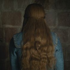 the back of a woman's head with long brown hair in a blue dress