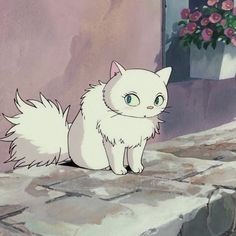 a white cat sitting on top of a stone floor next to a potted plant