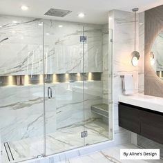 a bathroom with marble walls and flooring next to a walk in glass shower stall