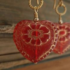 "Beautiful red glass hearts, etched in gold, hang from delicate, twisted wire loops and decorative earwires of vermeil. A lovely gift for yourself or somebody else on Valentine's Day. Length from bottom loop of earwire: 1\"(25mm) Diameter of heart: 3/4\"(20mm) All Debra Dane jewelry arrives in a pretty box suitable for gifting. These earrings are also available with non-pierced gold plated clips. They will have a gold ball instead of the ornate piece that is on the pierced earwires." Handmade Heart Earrings For Wedding On Valentine's Day, Heart Pendant Earrings With Beads For Gift, Gold Double Heart Handmade Earrings, Handmade Festive Jewelry For Valentine's Day, Handmade Heart Earrings For Valentine's Day Gift, Yellow Gold Heart Earrings As Gift, Festive Gold Jewelry With Heart Beads, Handmade Double Heart Gold Earrings, Red Brass Jewelry For Anniversary