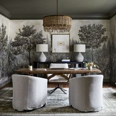 a dining room table with two chairs and a chandelier hanging from the ceiling