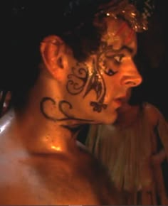 a man with tattoos on his face and chest