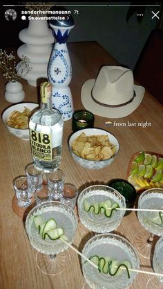 the table is set up with glasses and plates of food, including cucumbers