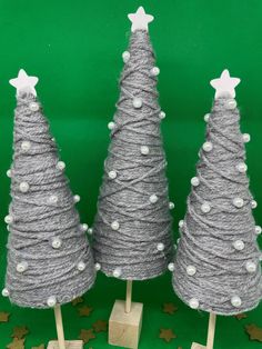 three christmas trees made out of yarn and wooden pegs with white stars on them