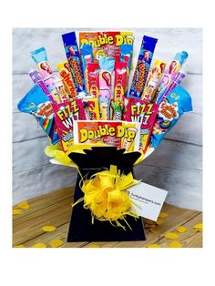 a bouquet of candy and lollipops in a black vase