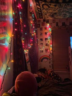 a bedroom decorated with christmas lights and pictures on the wall, along with a flat screen tv