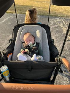 a baby in a stroller being held by a woman