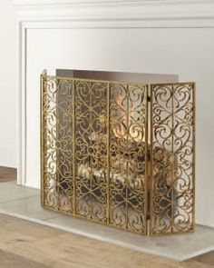 an ornate gold fireplace screen in a white room