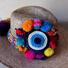 This Key West Collection Is To Showcase Our Beautiful Handmade Straw Hats Made In Mexico All Of The Decorations Are Done By Hand . This Beautiful Handmade Summer Hat Has Vibrant Colored Pom Poms, Crochet Evil Eye And Woven Colorful Band. Each Hat Is A One-Of-A-Kind Piece Of Artwork, Rim: 4 Inches Height: 5 Inches Evil Eye: Approx. 3 Inches Diameter The Band Is Approx. 2 Inches Thick. It Also Hast A Elastic Strap Inside For Comfort And Fit Woven Straw Panam Hat Style Crochet Band And Protective E Colorful Wide Brim Sun Hat For Vacation, Multicolor Hats For Beach Season Travel, Multicolor Hats For Travel And Beach Season, Multicolor Hats For Travel During Beach Season, Handmade Blue Sun Hat For Vacation, Handmade Multicolor Sun Hat For Vacation, Panama Hat Style, Crochet Evil Eye, Eclipse Party