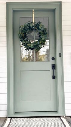 a green front door with a wreath on it