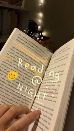 someone is reading a book with smiley face stickers on it