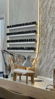 a desk with a lamp and some bottles on the shelf next to it in front of a window