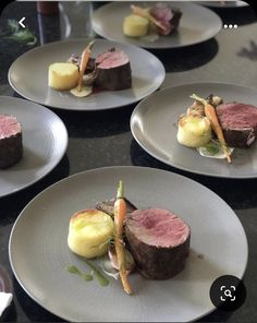 four white plates with different types of food on top of each one, including meat and vegetables