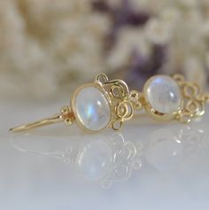 "These Moonstone gold dangle earrings are fine jewelry earrings, 14k solid gold and Moonstone gemstones. These earrings have an oriental style design. You will love the special color combination of the stone with the solid gold. The yellow gold and the white shades of the Moonstone are so beautiful together that you will want to look at all the time. The earrings can be made with other type of stones, every new combination is a surprise for me. You can ask me about different gemstone. Please loo Fine Jewelry 14k Gold Filled Round Earrings, 14k Gold Filled Round Fine Jewelry Earrings, 14k Yellow Gold Gemstone Earrings, Delicate 14k Gold Round Earrings, Elegant 14k Gold Earrings With Gemstones, Elegant 14k Gold Gemstone Earrings, Handmade Moonstone Jewelry In Yellow Gold, Handmade Yellow Gold Moonstone Jewelry, Elegant Moonstone Earrings For Formal Occasions