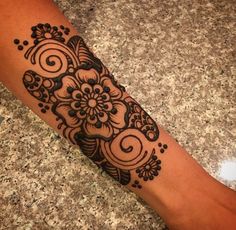 a woman's foot with a henna tattoo design on the side of her leg