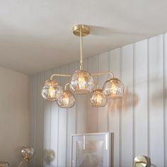 a chandelier hanging from the ceiling in a room with white walls and striped wallpaper