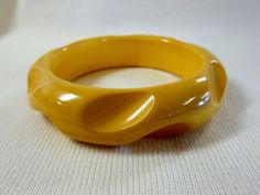 "Carved, rounded bangle bracelet in cream corn yellow. Measures 3 1/2\" across, 3/4\" thick. Simichrome tested, guaranteed to be Bakelite." Retro Yellow Bangle Bracelets, Retro Yellow Bangle Bracelet, Vintage Yellow Round Bracelets, Retro Yellow Adjustable Bracelets, Cream Corn, Bakelite Brooch, Bakelite Bracelets, Lotus Necklace, Bakelite Bangles