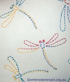 the dragonflys are drawn on paper with colored thread