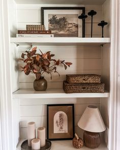 a shelf with some pictures and candles on it