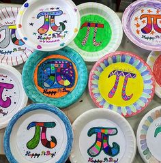 colorful paper plates with the letters pi painted on them are arranged in a row and displayed