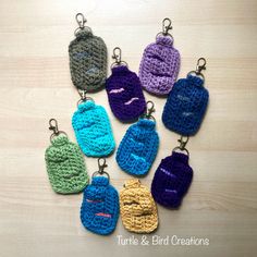 crocheted keychains are arranged in the shape of mittens with faces on them