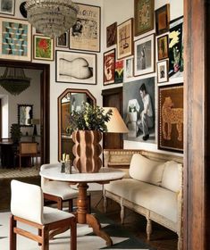 a living room with pictures on the wall and furniture in front of an entry way