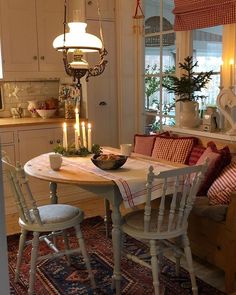 a dining room table with two chairs and a bowl on top of it in front of a window