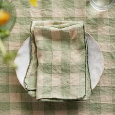 a green and white checkered table cloth on top of a plate with silverware