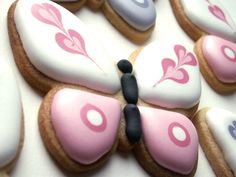 decorated cookies in the shape of butterflies with pink and white frosting on each cookie