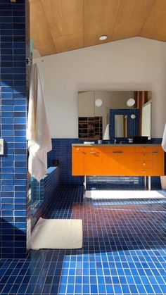 a bathroom with blue tiles and orange cabinets