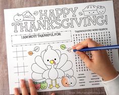 a person holding a pencil and writing on a thanksgiving coloring page with a turkey in the center