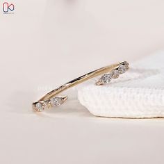 a pair of gold rings with diamonds on white napkin next to the ring and earring