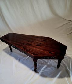 a wooden table sitting on top of a white sheet