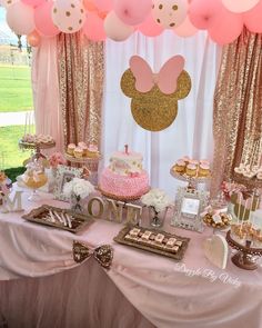 a pink and gold minnie mouse themed birthday party with cake, cupcakes and balloons