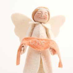 an angel figurine with love written on it's chest and orange ribbon