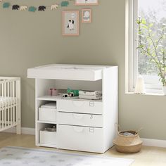 a baby's room with a crib, dresser and changing table in it