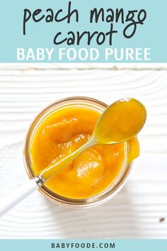 peach mango carrot baby food puree in a glass jar with a spoon on top