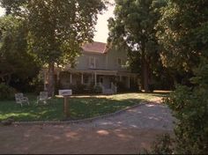 the house is surrounded by trees and grass