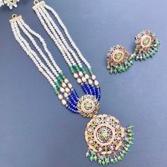 Elegant and intricately crafted emerald sapphire and pearl string necklace in 22k hallmarked gold. The necklace weighs 32 GMs including 16.55 GMs in hanging and stringing beads The earrings weigh 10.76 including 1.68 GMs of hanging beads Price Breakup Summary Component Rupees % of Total 22k Gold 125,191 72.7% Stones & Beads 19,359 11.2% Making Charges 22,534 13.1% Taxes (GST) 5,013 2.9% Total 172,096 100.0% View Detailed Price Breakup Traditional 22k Gold Necklace With Pearl Pendant, Temple Jewelry Necklace With Pearl Drop And Round Beads, Traditional Gold Beaded Necklace With Pearl Pendant, Traditional Pearl Necklace With Round Beads, Gold Pearl Necklace With Gemstone In Traditional Style, Traditional Gold Pearl Necklace With Gemstone, Traditional Round Pearl Drop Necklaces, Temple Jewelry Pearl Gemstone Necklace For Celebrations, Temple Jewelry Style Pearl Necklace For Celebration