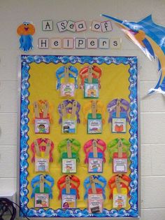 a bulletin board with some pictures on it and two dolphin balloons in the air next to it