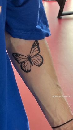 a person with a butterfly tattoo on their arm