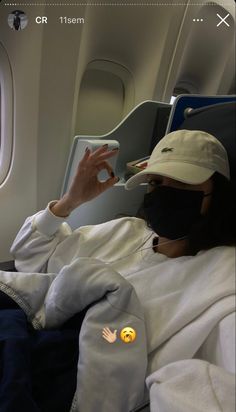 a person wearing a face mask while sitting on an airplane